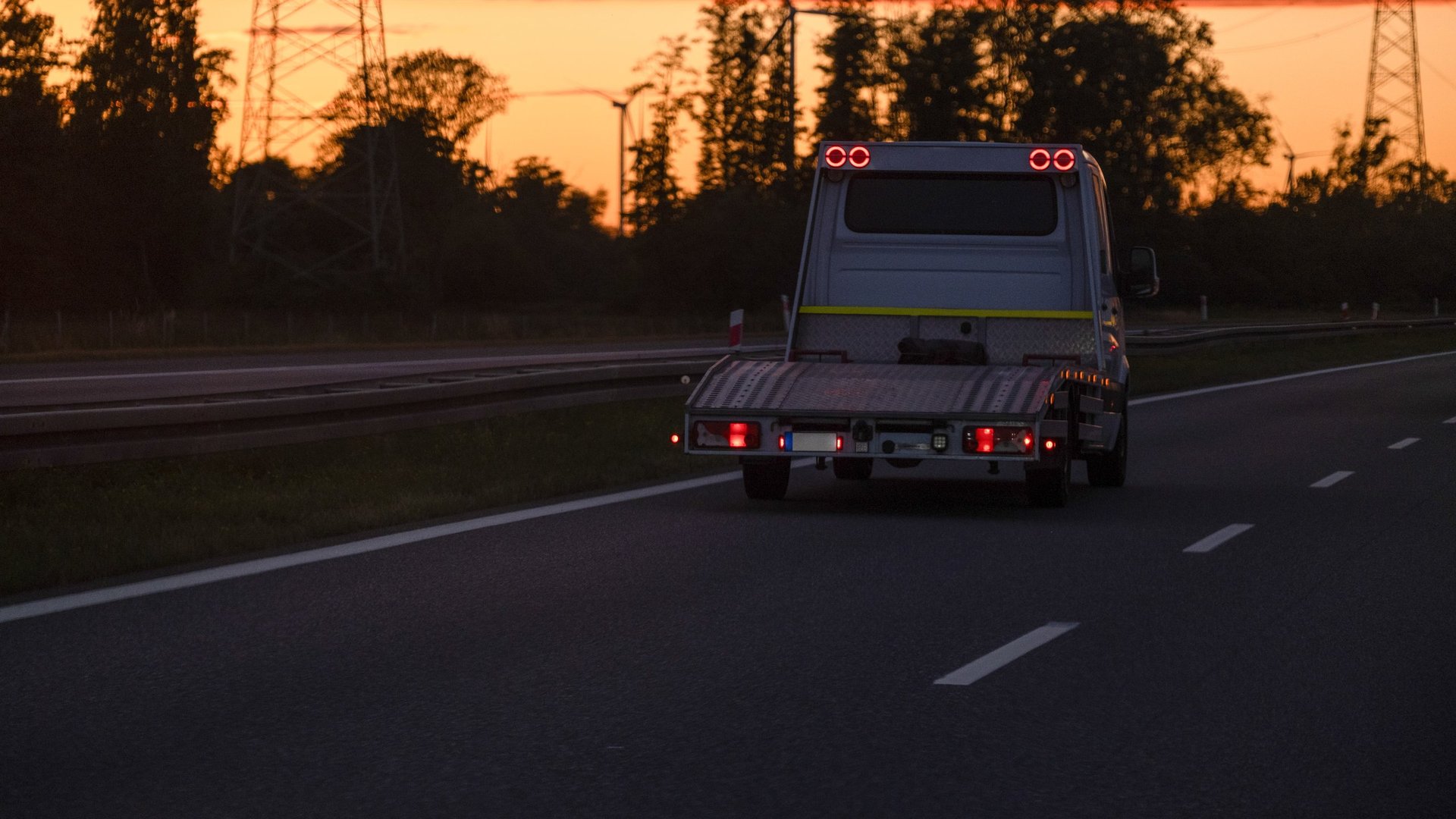 Grúa cerca de mí en Chantilly VA - camión de grúa de Onyx Auto Towing en la carretera al atardecer